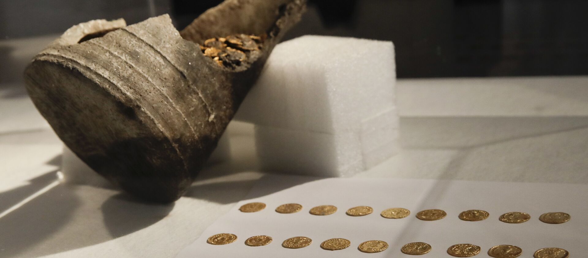 Ancient gold coins are displayed in a plexiglass case during a news conference, in Milan, Italy, Monday, Sept. 10, 2018. Hundreds of gold coins of the late imperial era, kept in a soapstone vessel of uncommon shape were discovered last Wednesday in the center of Como, northern Italy, during restructuring works inside a theater. (AP Photo/Luca Bruno) - Sputnik International, 1920, 16.09.2018