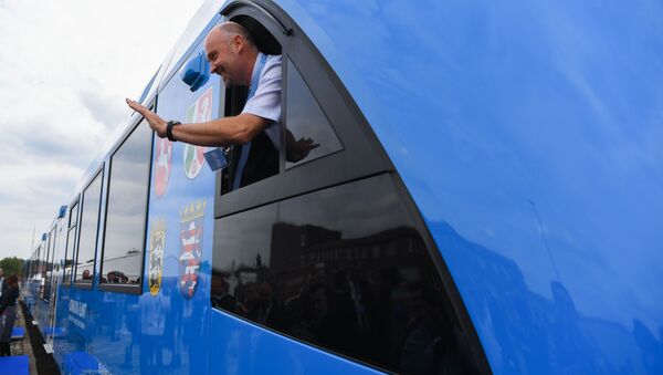 An employee of French train maker Alstom, waves from a window upon the arrival of Alstom's first hydrogen-powered train at the train station in Bremervoerde, Germany as it enters service on September 16, 2018.  Patrik STOLLARZ / AFP - Sputnik International
