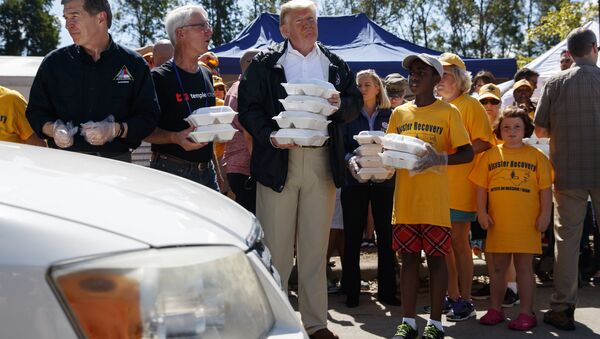 President Donald Trump hands out prepackaged meals to people in cars at Temple Baptist Church in an area impacted by Hurricane Florence. - Sputnik International