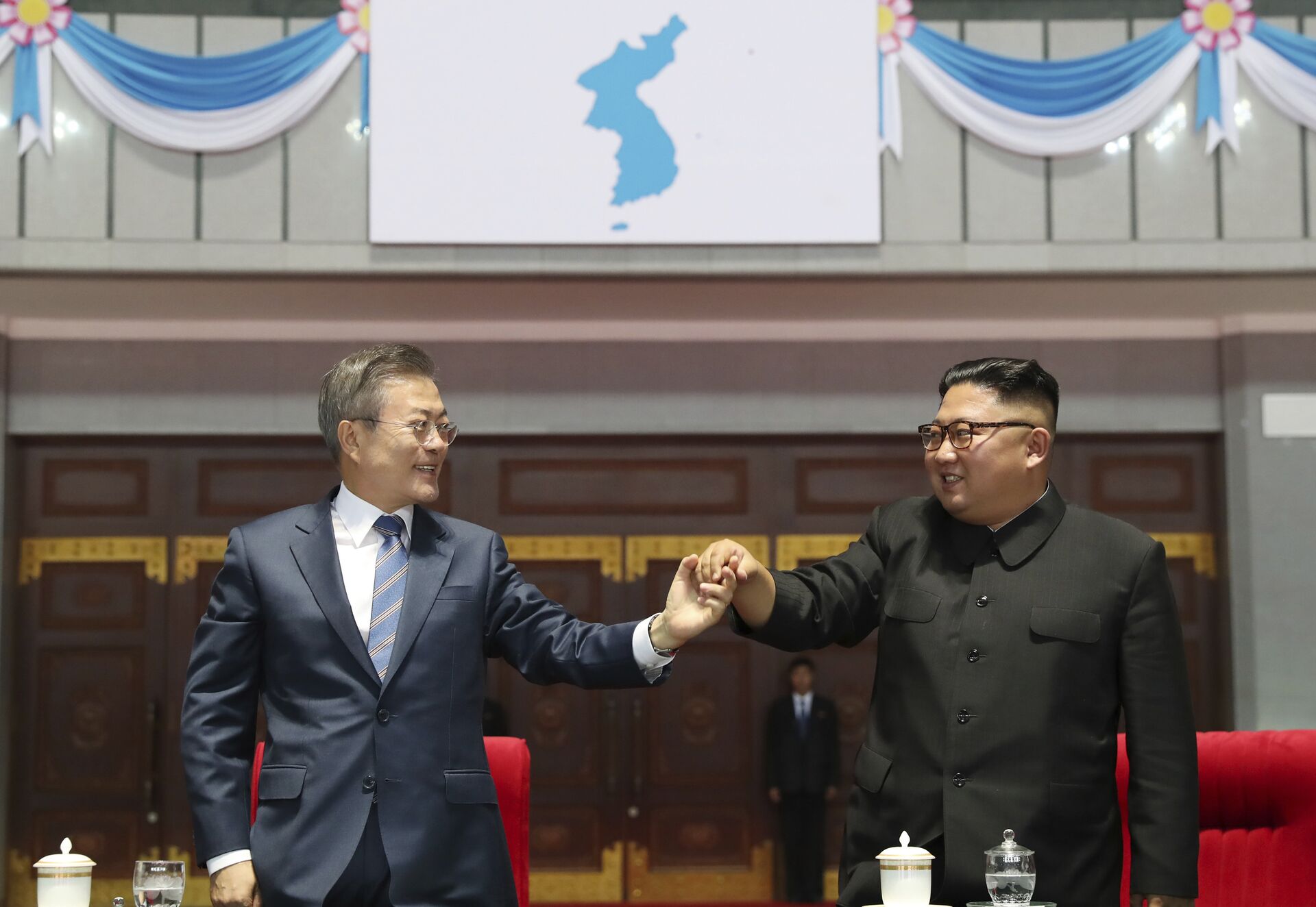 South Korean President Moon Jae-in, left, and North Korean leader Kim Jong Un hold their hands after watching the mass games performance of The Glorious Country at May Day Stadium in Pyongyang, North Korea, Wednesday, Sept. 19, 2018. Unification flag symbol at top centre. - Sputnik International, 1920, 22.04.2022