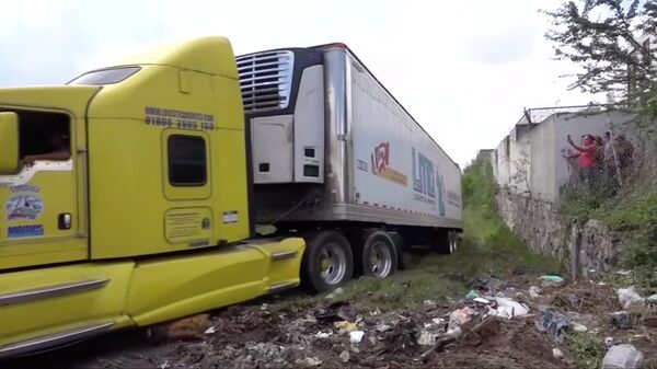 A truck leaves with an abandoned trailer full of bodies that has been parked in Tlajomulco de Zuniga, Jalisco, Mexico September 15, 2018 in this still image taken from a video obtained September 17, 2018.  - Sputnik International