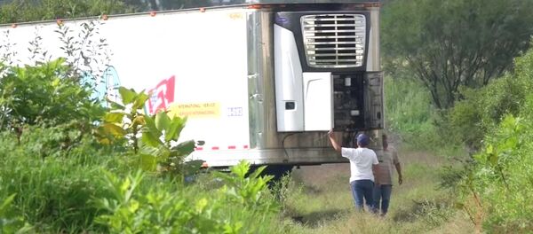 Men stand by an abandoned trailer full of bodies that has been parked in Tlajomulco de Zuniga, Jalisco, Mexico September 15, 2018 in this still image taken from a video obtained September 17, 2018. Men stand by an abandoned trailer full of bodies that has been parked in Tlajomulco de Zuniga, Jalisco, Mexico September 15, 2018 in this still image taken from a video obtained September 17, 2018. - Sputnik International