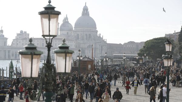 Tourists stroll in downtown Venice, Italy, Saturday, Nov. 12, 2016. Since 1951, Venice's population has steadily shrunk from 175,000 to some 55,000. Several factors are blamed, including high prices driven by a boom in tourism, the logistics of supplying a carless city, and the erosion of canal-side apartment buildings by lapping waters - Sputnik International