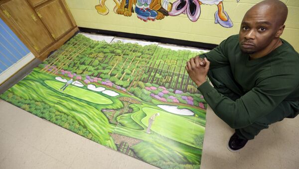 Valentino Dixon in prison with one of the hundreds of golf course drawings he created behind bars - Sputnik International