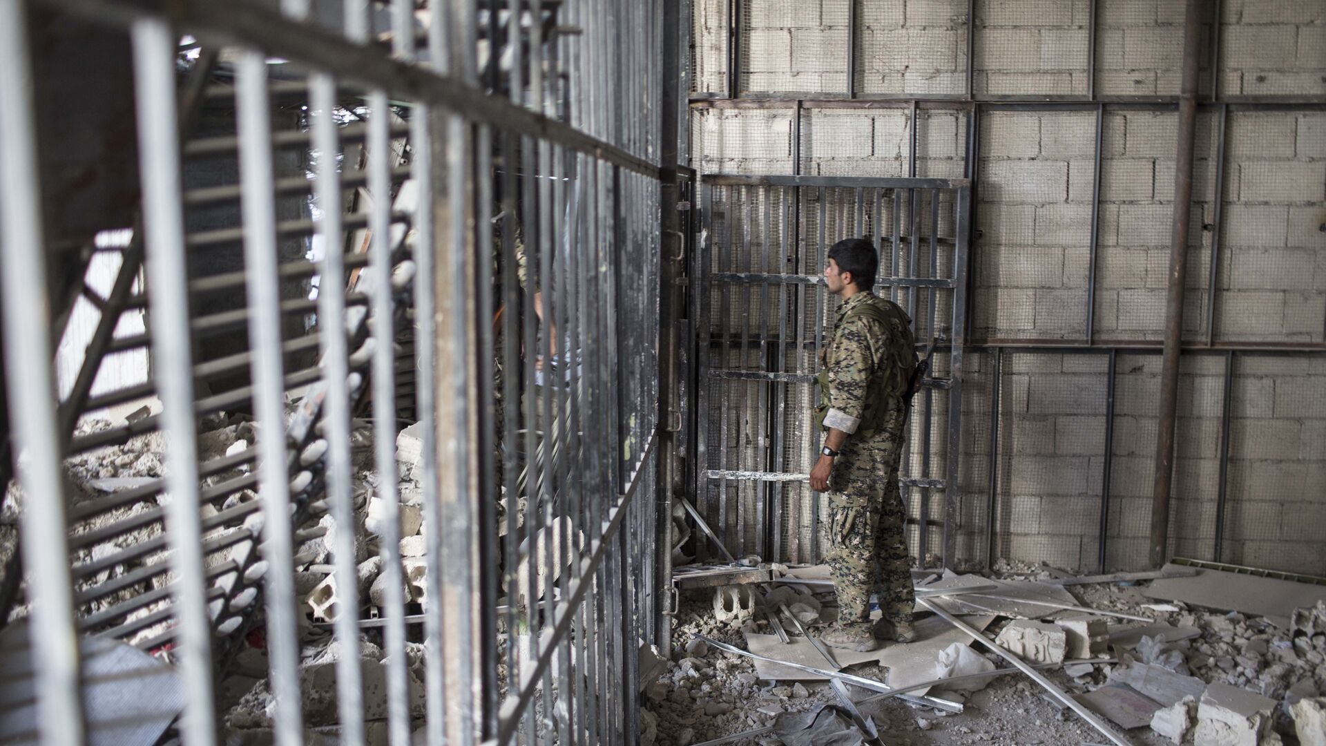A member of the U.S.-backed Syrian Democratic Forces (SDF) walks inside a prison built by Islamic State fighters at the stadium that was the site of Islamic State fighters' last stand in the city of Raqqa, Syria, Friday, Oct. 20, 2017 - Sputnik International, 1920, 19.06.2022