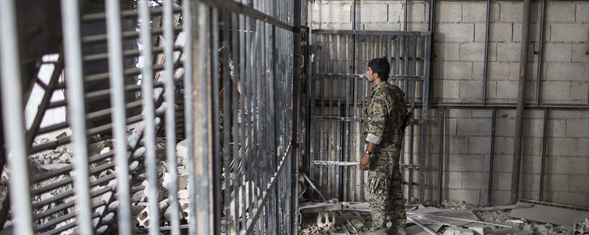 A member of the U.S.-backed Syrian Democratic Forces (SDF) walks inside a prison built by Islamic State fighters at the stadium that was the site of Islamic State fighters' last stand in the city of Raqqa, Syria, Friday, Oct. 20, 2017 - Sputnik International, 1920, 19.06.2022