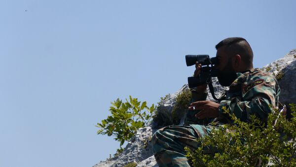 Syrian soldier chilling on a hilltop with a cigarette as he monitors artillery strikes against militant positions in Latakia. - Sputnik International