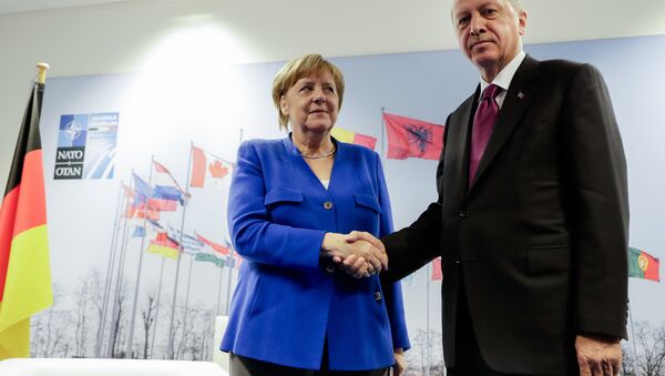German Chancellor Angela Merkel, left, and Turkish President Recep Tayyip Erdogan, right, shake hands prior to a bilateral meeting on the sideline of a summit of heads of state and government at NATO headquarters in Brussels Wednesday, July 11, 2018 - Sputnik International