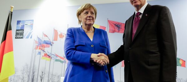 German Chancellor Angela Merkel, left, and Turkish President Recep Tayyip Erdogan, right, shake hands prior to a bilateral meeting on the sideline of a summit of heads of state and government at NATO headquarters in Brussels Wednesday, July 11, 2018 - Sputnik International