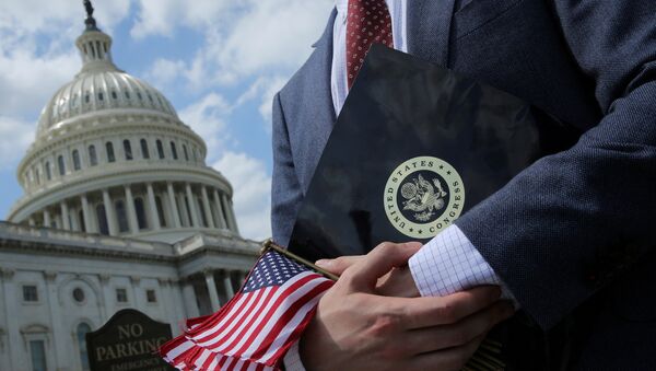 A congressional aide holds flags to give to participants at rally at the U.S. Capitol in Washington, U.S. May 21, 2018 - Sputnik International