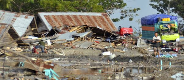 A man stands amid the damage caused by a tsunami in Palu, Central Sulawesi, Indonesia, Saturday, Sept. 29, 2018. A powerful earthquake rocked the Indonesian island of Sulawesi on Friday, triggering a 3-meter-tall (10-foot-tall) tsunami that an official said swept away houses in at least two cities. - Sputnik International