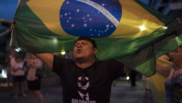 A man sings the Brazil's national anthem as he waves the national flag in support leading presidential candidate Jair Bolsonaro, outside Bolsonaro's residence in Rio de Janeiro, Brazil - Sputnik International