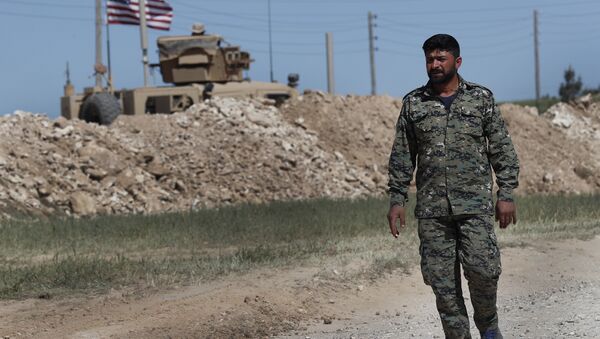 In this April 4, 2018 file photo, a U.S-backed Syrian Manbij Military Council soldier passes a U.S. position near the tense front line with Turkish-backed fighters, in Manbij, north Syria - Sputnik International