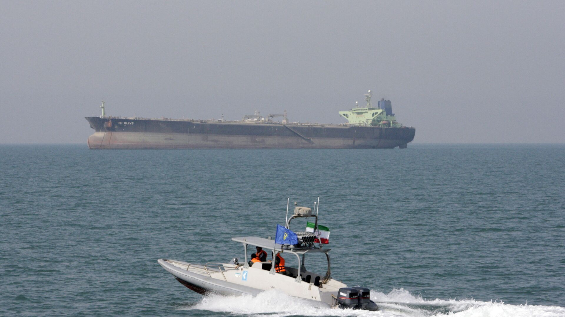 In this July 2, 2012 file photo, an Iranian Revolutionary Guard speedboat moves in the Persian Gulf while an oil tanker is seen in background - Sputnik International, 1920, 11.05.2022