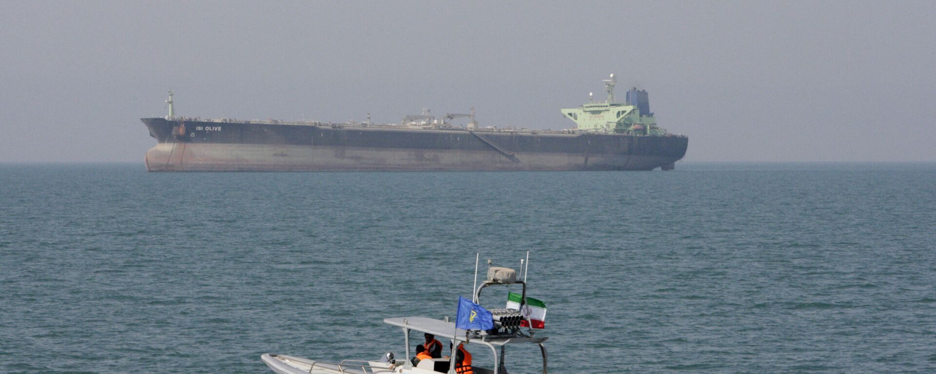 In this July 2, 2012 file photo, an Iranian Revolutionary Guard speedboat moves in the Persian Gulf while an oil tanker is seen in background - Sputnik International, 1920, 11.05.2022