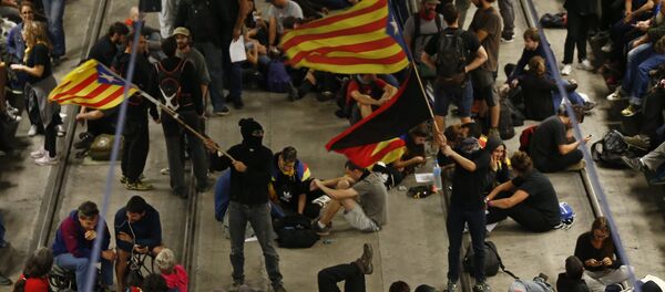 Activists advocating for Catalan secession wave Catalonian independence flags as others sit on the railway tracks at the station in Girona, Spain, Monday Oct. 1, 2018 Activists advocating for Catalan secession wave Catalonian independence flags as others sit on the railway tracks at the station in Girona, Spain, Monday Oct. 1, 2018 - Sputnik International