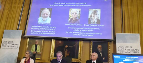 Members of the Nobel Committee for Physics (L-R) Olga Botner, Goran K Hansson and Mats Larsson sit in front of a screen displaying portraits of Arthur Ashkin of the United States, Gerard Mourou of France and Donna Strickland of Canada during the announcement of the winners of the 2018 Nobel Prize in Physics. - Sputnik International