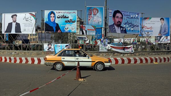 A vehicle drives in front of election posters of parliamentarian candidates installed during the first day of elections campaign in Kabul, Afghanistan September 28, 2018 - Sputnik International