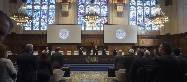 The delegations of the U.S., front left, and the Islamic Republic of Iran, front right, rise as judges, rear, enter the International Court of Justice, or World Court, in The Hague, Netherlands, Wednesday, Oct. 3, 2018, to rule on an Iranian request to order Washington to suspend sanctions against Tehran - Sputnik International