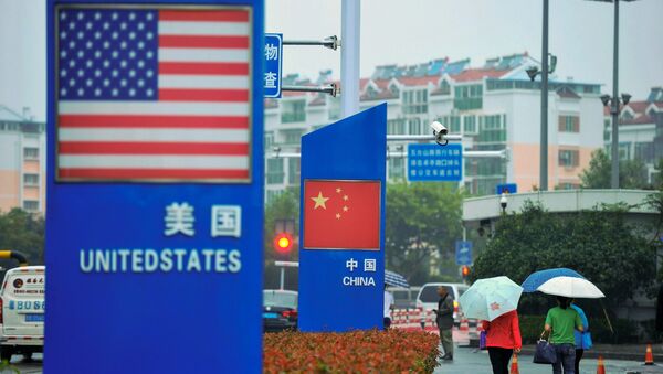 Signs with the US flag and Chinese flag are seen outside a store selling foreign goods in Qingdao in China's eastern Shandong province on September 19, 2018 - Sputnik International