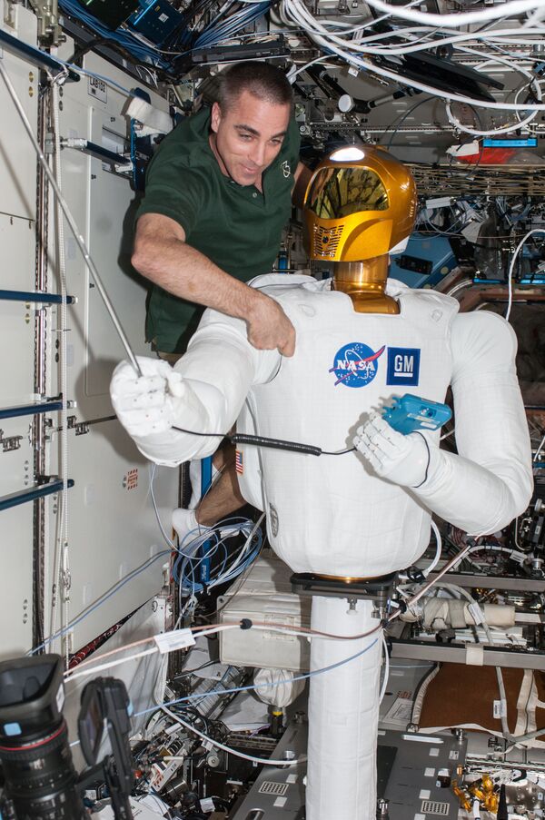 NASA astronaut Chris Cassidy, Expedition 36 flight engineer, works with Robonaut 2, the first humanoid robot in space, during a round of ground-commanded tests in the Destiny laboratory of the International Space Station. NASA astronaut Chris Cassidy, Expedition 36 flight engineer, works with Robonaut 2, the first humanoid robot in space, during a round of ground-commanded tests in the Destiny laboratory of the International Space Station. - Sputnik International