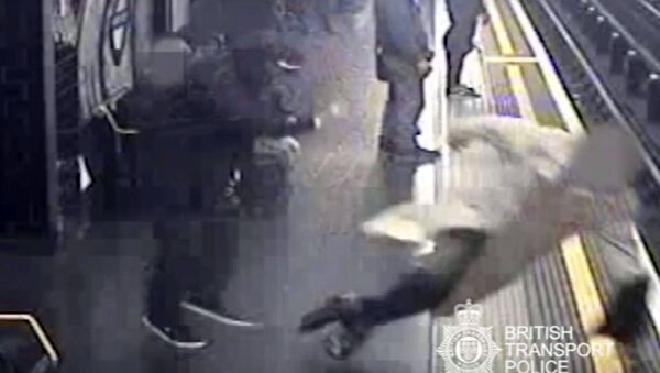 This handout grab taken from CCTV issued by British Transport Police shows Robert Malpas being pushed onto the tracks of Marble Arch Underground station in London - Sputnik International