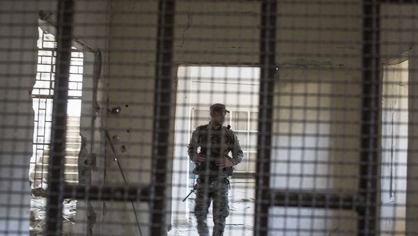 A member of the U.S.-backed Syrian Democratic Forces (SDF) walk inside a prison built by Islamic State fighters at the stadium that was the site of IS fighters' last stand in the city of Raqqa, Syria, Friday, Oct. 20, 2017 - Sputnik International