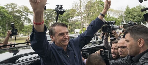 Presidential frontrunner Jair Bolsonaro, of the Social Liberal Party, flashes thumbs up to supporters after voting at a polling station in Rio de Janeiro, Brazil, Sunday, Oct. 7, 2018. - Sputnik International
