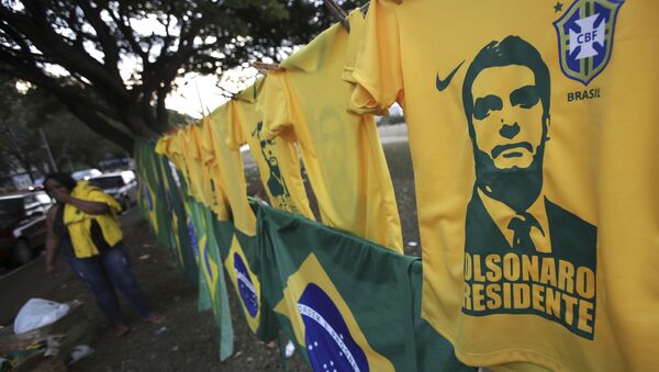 A woman sells t-shirts and flags with the image of presidential frontrunner Jair Bolsonaro in front of the headquarters of the national congress in Brasilia - Sputnik International