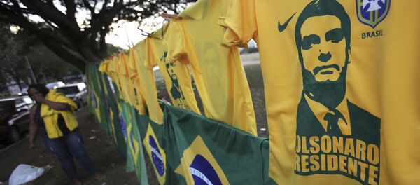 A woman sells t-shirts and flags with the image of presidential frontrunner Jair Bolsonaro in front of the headquarters of the national congress in Brasilia - Sputnik International