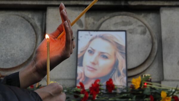 A woman holds a candle next to a portrait of slain television reporter Viktoria Marinova during a vigil at the Liberty Monument in Ruse, Bulgaria, Monday, Oct. 8, 2018. - Sputnik International