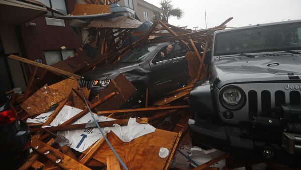 A storm chaser climbs into his vehicle during the eye of Hurricane Michael to retrieve equipment after a hotel canopy collapsed in Panama City Beach, Fla., Wednesday, Oct. 10, 2018 - Sputnik International