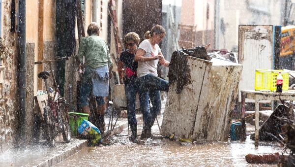 Residents place their damaged belongings on the street under pouring rain, in Sant Llorenc, 60 kilometers (40 miles) east of Mallorca's capital, Palma, Spain, Wednesday, Oct. 10, 2018. - Sputnik International
