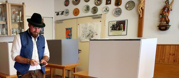 A man in traditional clothes casts his vote for the Bavarian state elections at a polling station in Maisach, Germany A man in traditional clothes casts his vote for the Bavarian state elections at a polling station in Maisach, Germany - Sputnik International