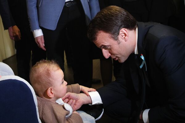 France's President Emmanuel Macron with a child during a visit to a hospital to mark the launch of a national autism plan in April 2018 - Sputnik International