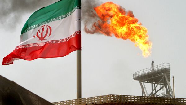 Gas flare on an oil production platform in the Soroush oil fields is seen alongside an Iranian flag in the Gulf July 25, 2005 - Sputnik International