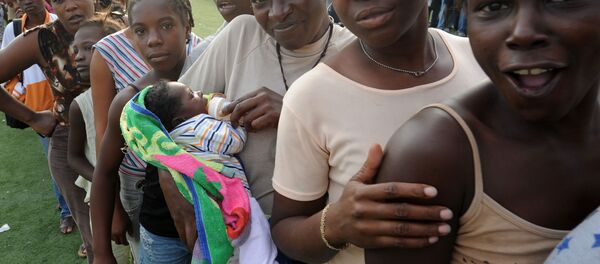 Women wait in line at a distribution point at the national stadium in Port-au-Prince on January 31, 2010. Women wait in line at a distribution point at the national stadium in Port-au-Prince on January 31, 2010. - Sputnik International