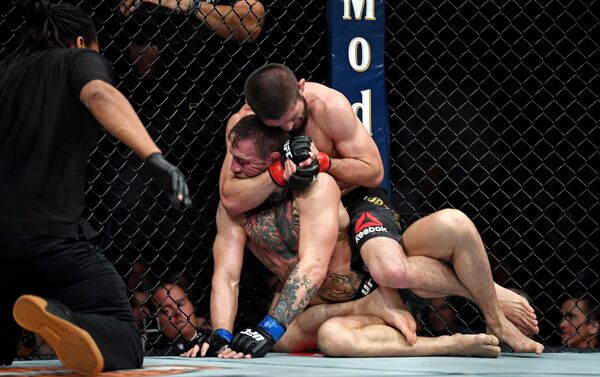 Khabib Nurmagomedov (red gloves) fights Conor McGregor (blue gloves) during UFC 229 at T-Mobile Arena - Sputnik International