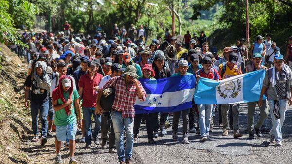 Honduran migrants take part in a new caravan heading to the US with Honduran and Guatemalan national flags in Quezaltepeque, Chiquimula, Guatemala on October 22, 2018 - Sputnik International