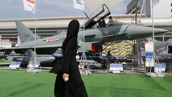 A woman walks past a Eurofighter Typhoon aircraft on display at a military show launching the International Defence Exhibition and Conference (IDEX) at the Abu Dhabi National Exhibition Centre in the Emirati capital on February 17, 2013 - Sputnik International