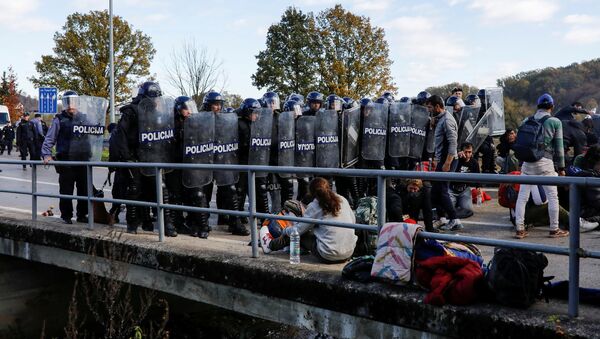 Croatian riot police stand guard in front of migrants at Maljevac border crossing between Bosnia and Croatia near Velika Kladusa, Bosnia, October 24, 2018 - Sputnik International
