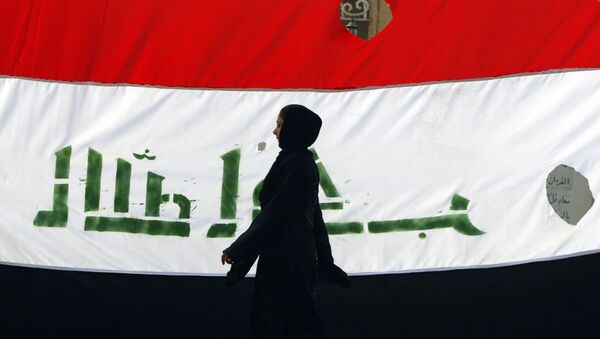 An Iraqi woman walks her national flag during a celebration marking the the departure of US troops from Iraq in Baghdad's Adhamiyah neighbourhood. File photo - Sputnik International