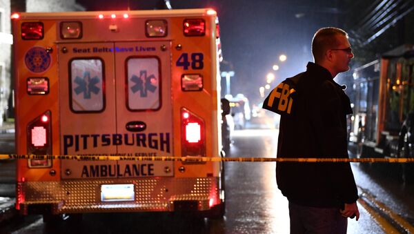 An FBI agent stands behind a police cordon and an ambulance outside the Tree of Life Synagogue (L) after a shooting there left 11 people dead in the Squirrel Hill neighborhood of Pittsburgh on October 27, 2018. - Sputnik International