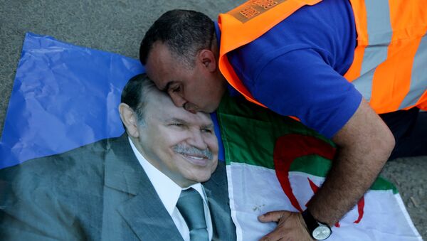 A supporter of Algerian President Abdelaziz Bouteflika kisses his picture as he celebrates in Algiers on April 18, 2014 after Bouteflika won a fourth term with 81,53% of the votes. - Sputnik International