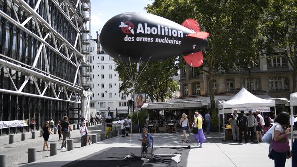 A woman sits underneath a balloon shaped like a nuclear bomb outside the Centre Georges Pompidou in Paris on August 7, 2017, during an action and four-day hunger strike organised by the network Sortir du nucleaire and the collective Abolition des armes nucleaires - Maison de Vigilance to call for the disarmament of nuclear weapons and for France to sign a UN treaty to ban nuclear weapons - Sputnik International