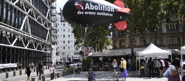 A woman sits underneath a balloon shaped like a nuclear bomb outside the Centre Georges Pompidou in Paris on August 7, 2017, during an action and four-day hunger strike organised by the network Sortir du nucleaire and the collective Abolition des armes nucleaires - Maison de Vigilance to call for the disarmament of nuclear weapons and for France to sign a UN treaty to ban nuclear weapons A woman sits underneath a balloon shaped like a nuclear bomb outside the Centre Georges Pompidou in Paris on August 7, 2017, during an action and four-day hunger strike organised by the network Sortir du nucleaire and the collective Abolition des armes nucleaires - Maison de Vigilance to call for the disarmament of nuclear weapons and for France to sign a UN treaty to ban nuclear weapons - Sputnik International