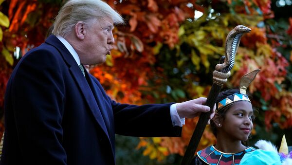 U.S. President Donald Trump waves the staff of a child dressed as a pharaoh as he hands out Halloween candy to trick-or-treaters at the White House in Washington, U.S., October 28, 2018 - Sputnik International