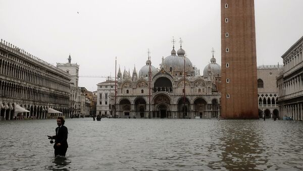 A man walks in the flooded St. Mark's Square during a high-water (Acqua Alta) alert in Venice on October 29, 2018 The flooding, caused by a convergence of high tides and a strong Sirocco wind, reached around 150 centimetres on October 29. - Sputnik International