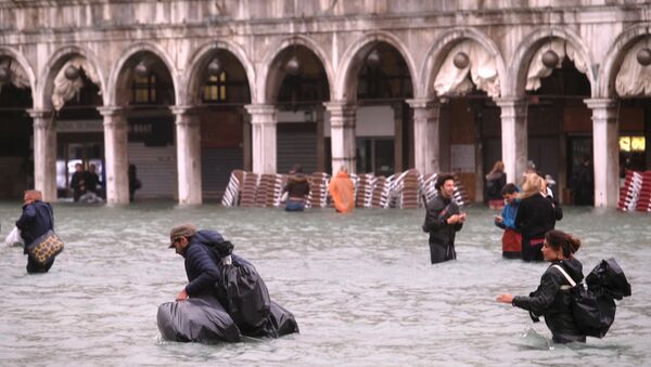 People walk in a flooded Saint Mark Square during a period of seasonal high water in Venice, Italy October 29, 2018 - Sputnik International