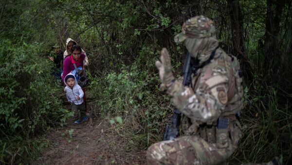 A member of the U.S. Border Patrol Tactical Unit (BORTAC) acknowledges family members after they illegally crossed the Rio Grande river into the United States from Mexico in Fronton, Texas, October 18, 2018 - Sputnik International
